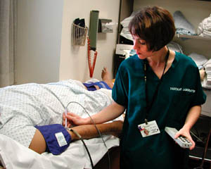 Un'infermiera che registra il volume del polso a un paziente.