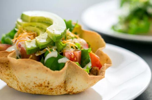 Insalata di taco in una ciotola di taco, con avocado sopra