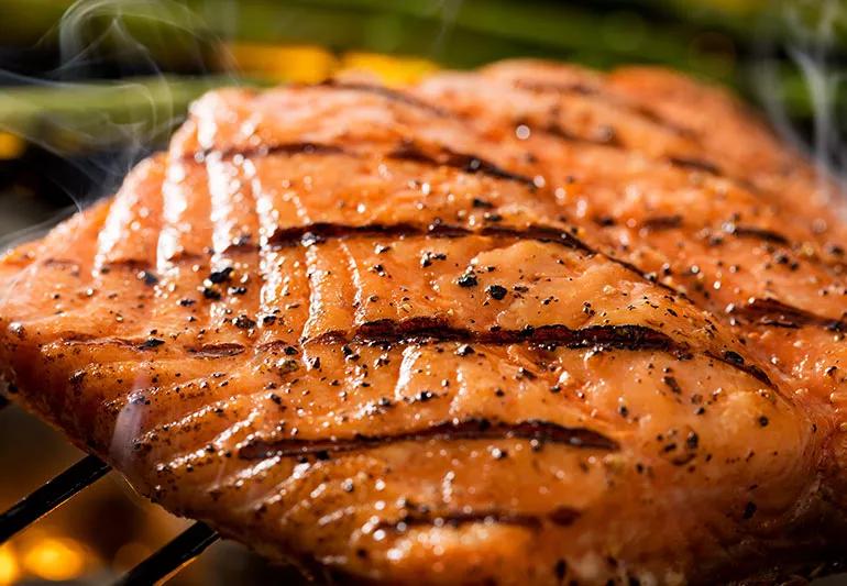 Salmone reale selvatico con segni di salmerino che cucina su una griglia all'aperto
