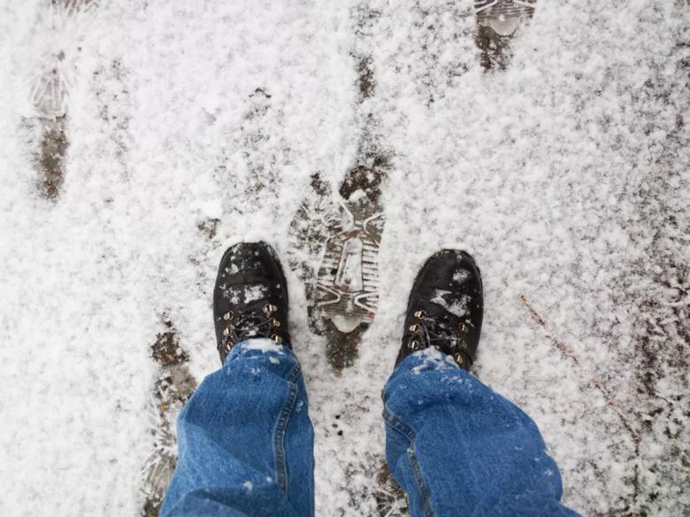 uomo che indossa stivali fuori con la neve a terra