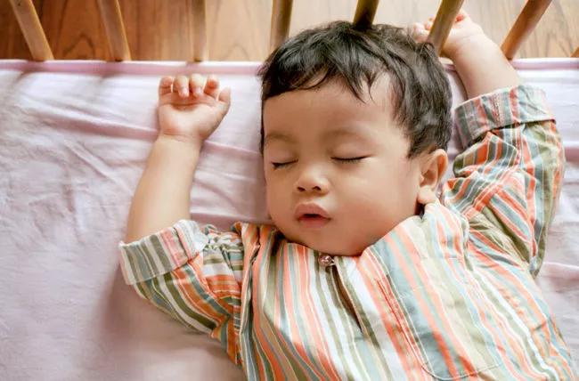 Un bambino che dorme in una culla.