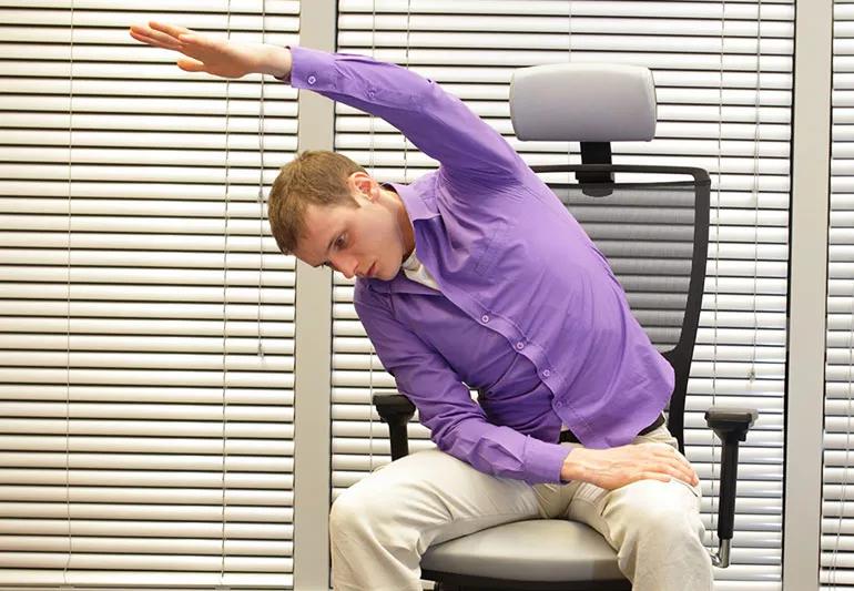 uomo che esegue esercizi di stretching yoga al lavoro