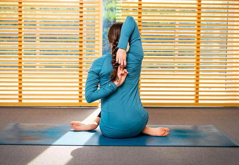 persona sul tappetino yoga in posizione del muso di mucca