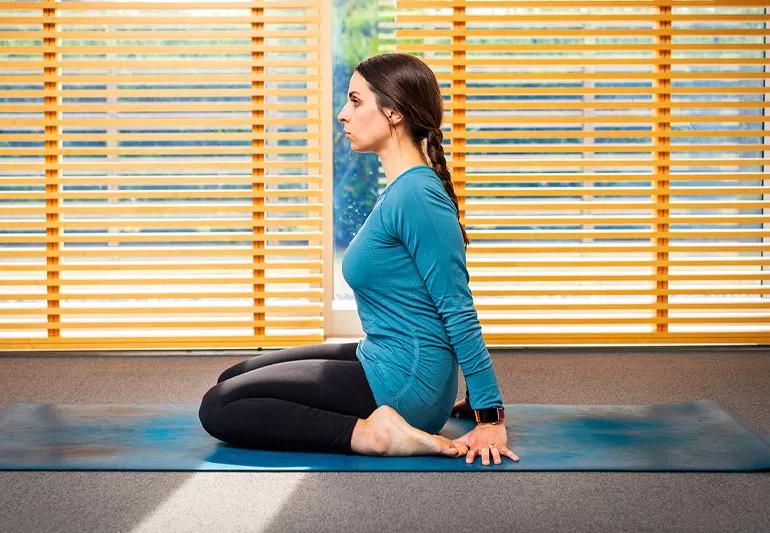 persona sul tappetino yoga in posizione dell'eroe