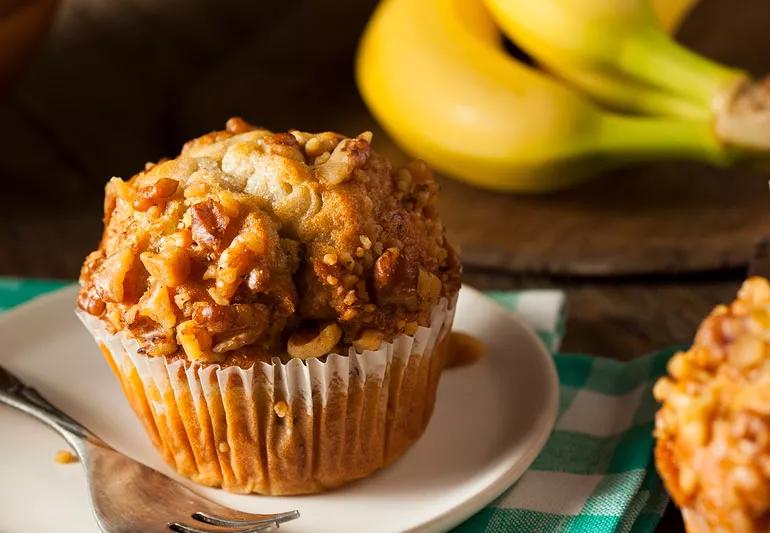 Muffin alle noci e banane con banane sullo sfondo